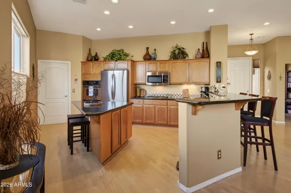 a kitchen with stainless steel appliances granite countertop wooden cabinets and a refrigerator