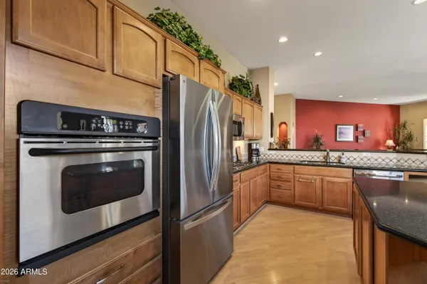 a kitchen with granite countertop a refrigerator stove and sink