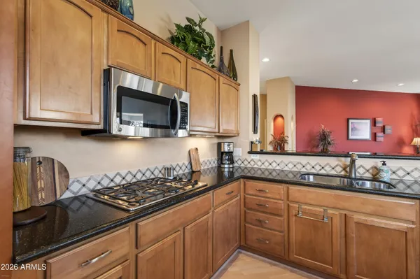 a kitchen with stainless steel appliances granite countertop a sink a stove microwave and cabinets