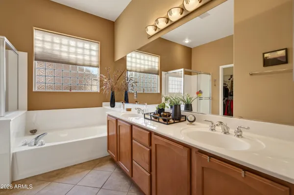 a bathroom with a tub double sink window and mirror