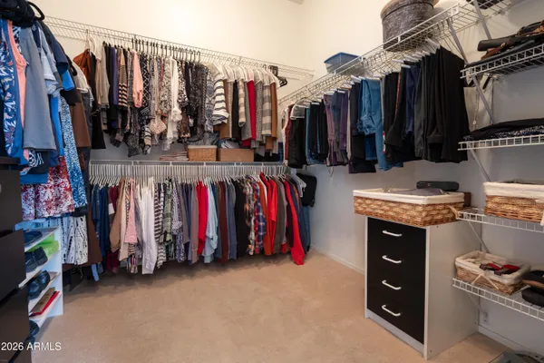 a view of walk in closet with clothes and shoes