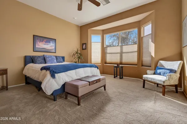 a spacious bedroom with a bed and glass window