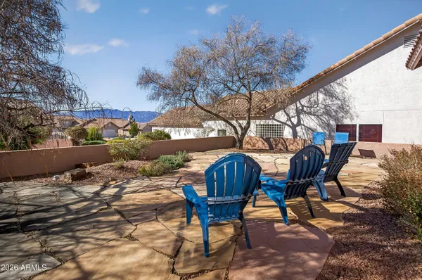 a patio with table and chairs and potted plants