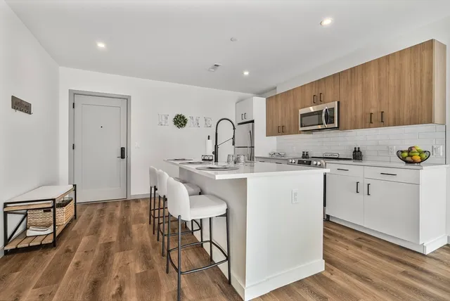 a kitchen with a sink cabinets and wooden floor