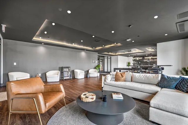 a living room with furniture and a dining table with kitchen view