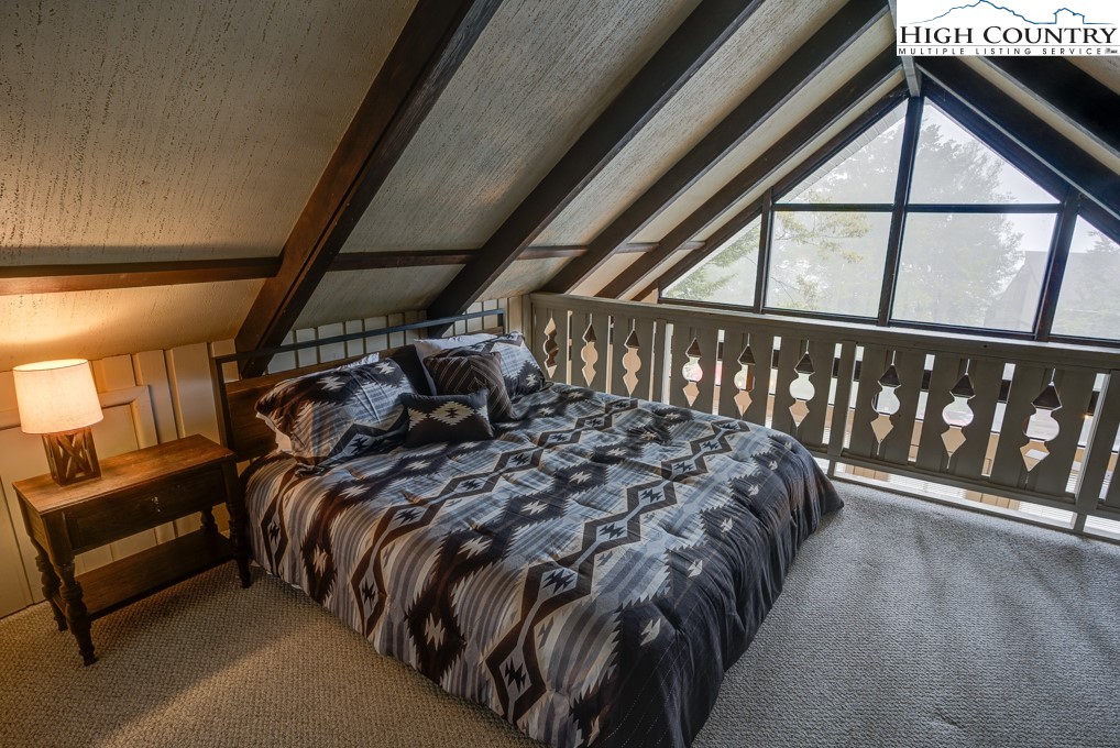 105 North Pinnacle Ridge Road, Unit 5 Beech Mountain, NC 28604 - Photo 12 of 35 a bed sitting in a bedroom next to a window