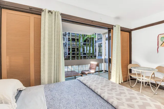 a bedroom with a bed and large windows