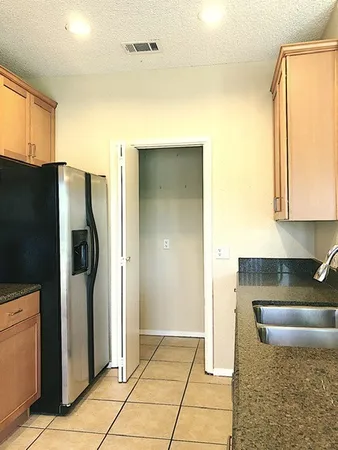 a kitchen with stainless steel appliances granite countertop a refrigerator and a stove