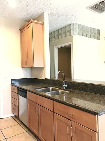 a kitchen with granite countertop a sink and cabinets