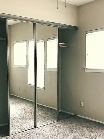 an empty room with a window and a ceiling fan