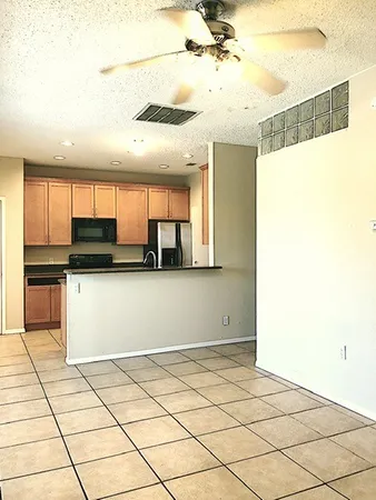 a kitchen with stainless steel appliances kitchen island granite countertop a refrigerator and a stove top oven