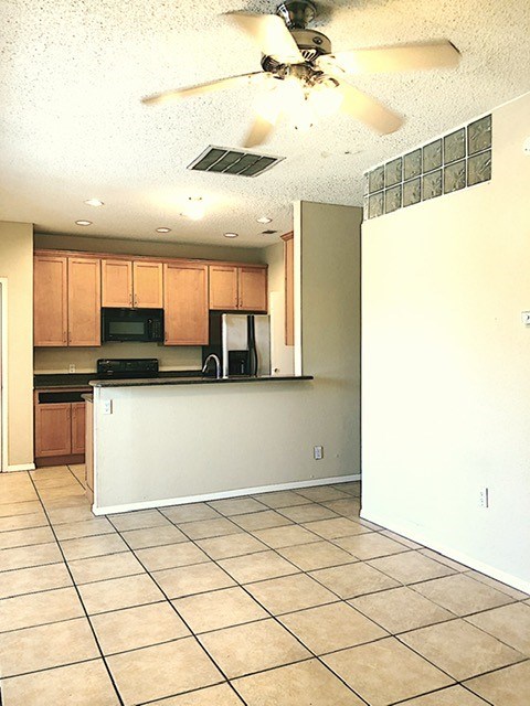 808 West 29th Street, Unit 301 Austin, TX 78705 - Photo 10 of 24 a kitchen with stainless steel appliances kitchen island granite countertop a refrigerator and a stove top oven
