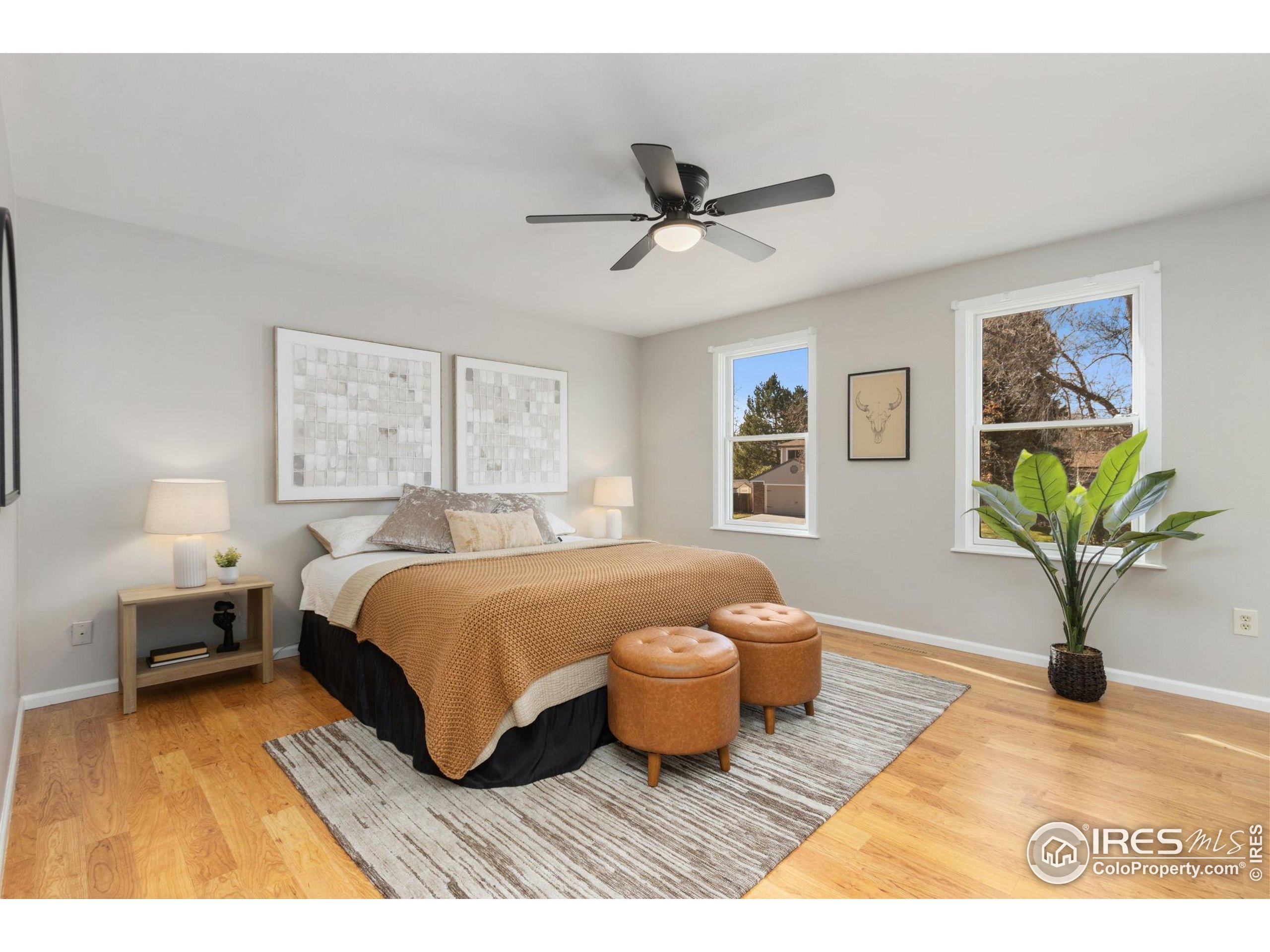 3024 Placer Court Fort Collins, CO 80526 - Photo 19 of 40 a spacious bedroom with a bed and a painting on the wall