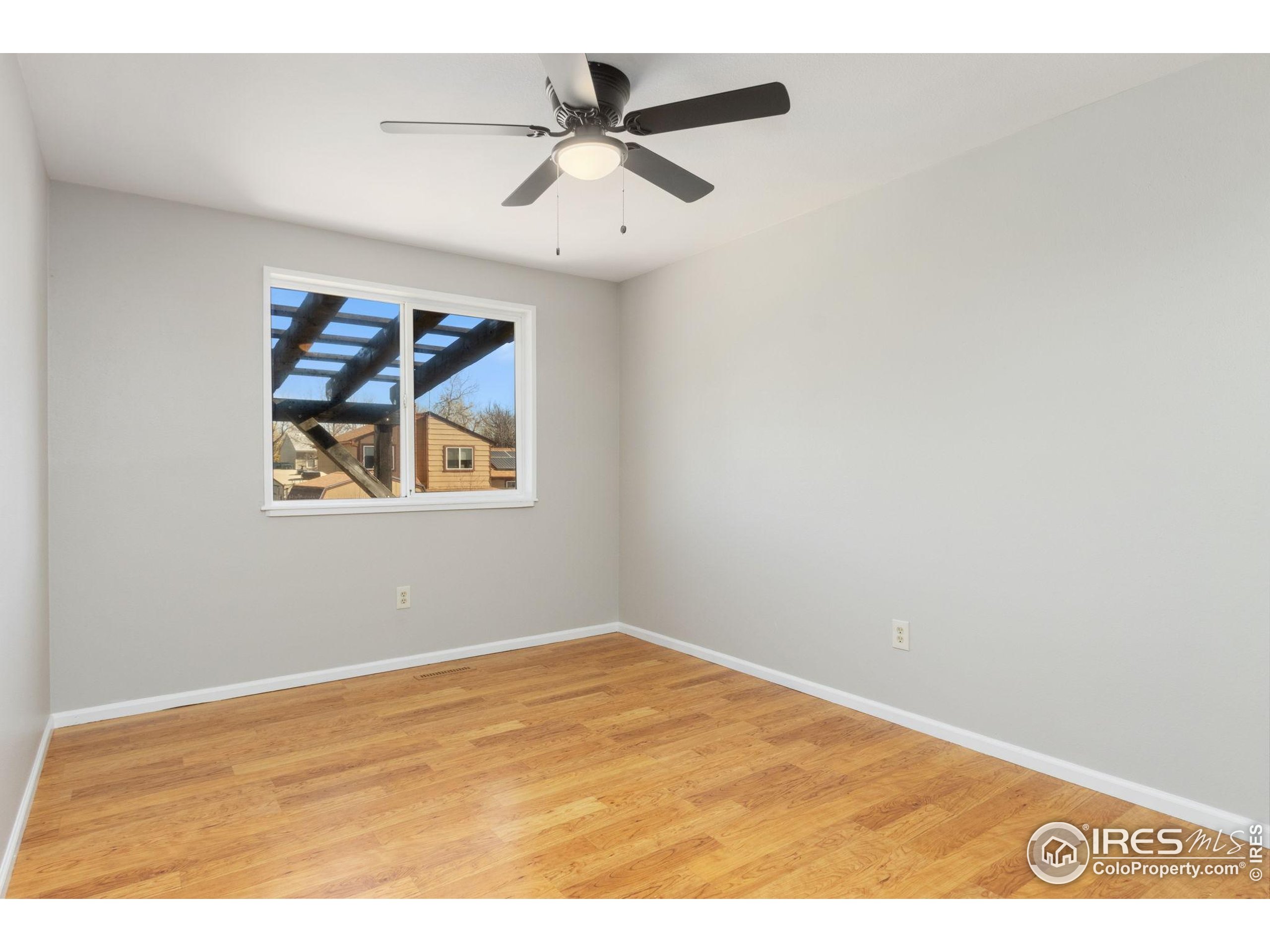 3024 Placer Court Fort Collins, CO 80526 - Photo 21 of 40 an empty room with a ceiling fan and wooden floor
