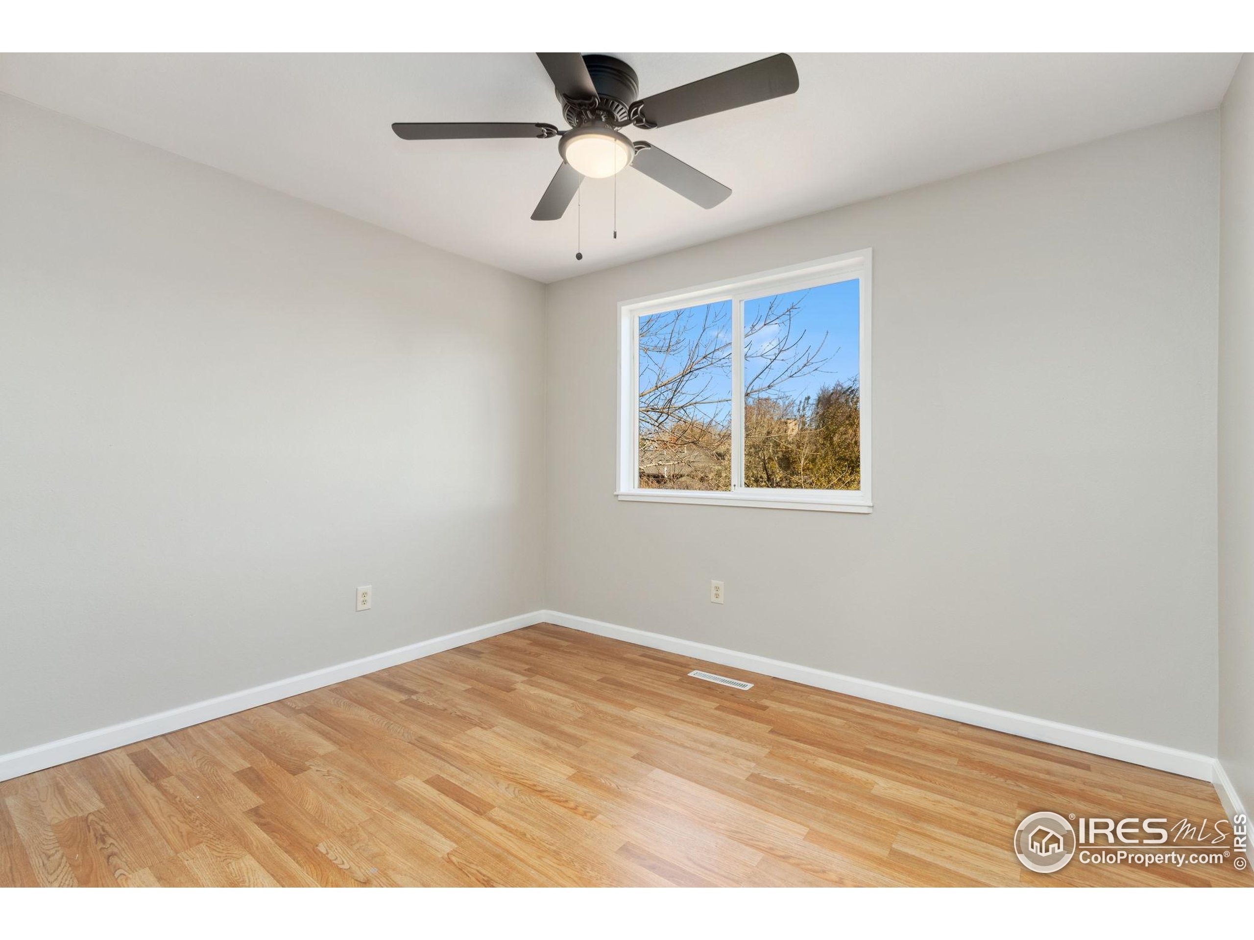 3024 Placer Court Fort Collins, CO 80526 - Photo 23 of 40 an empty room with a ceiling fan and wooden floor