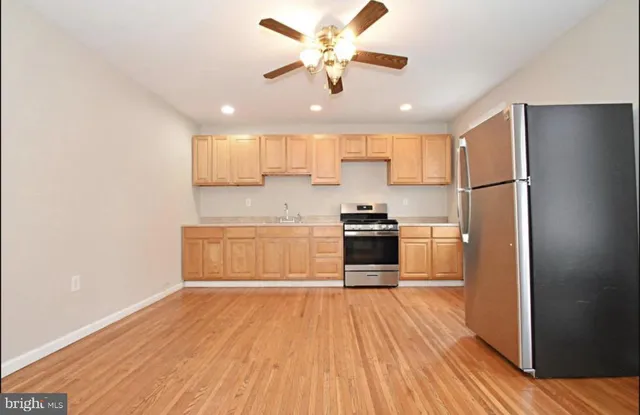 a kitchen with a refrigerator and a stove top oven