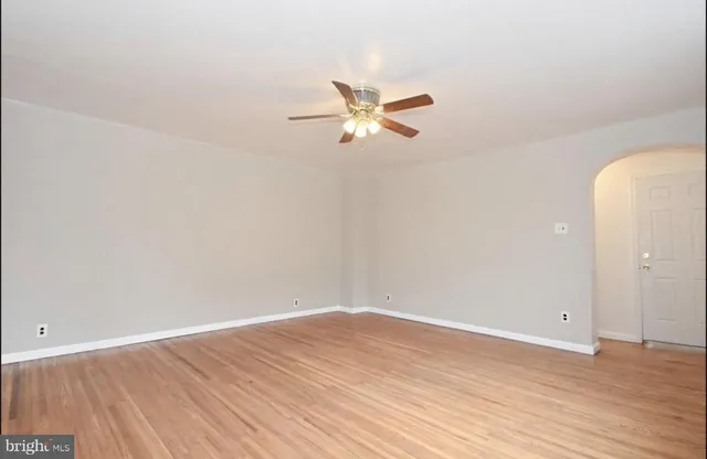 a view of a room with wooden floor and a ceiling fan