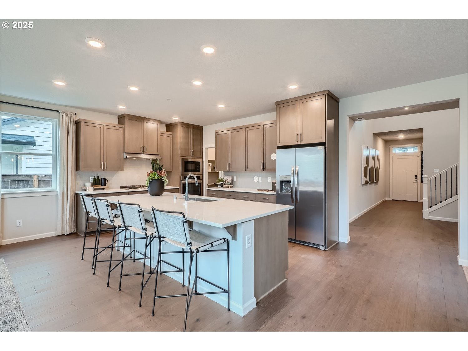 2600 South 6th Way Ridgefield, WA 98642 - Photo 5 of 33 a kitchen with stainless steel appliances kitchen island granite countertop a stove top oven a sink a refrigerator with white cabinets and wooden floor