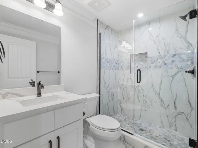 a bathroom with a sink toilet vanity and shower