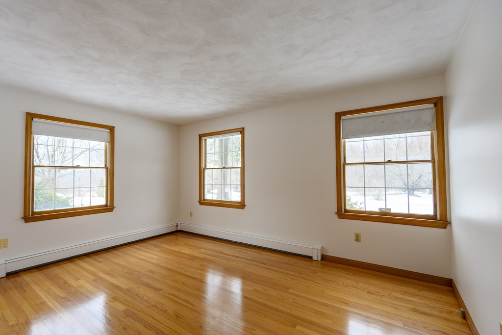 208 Rolling Ridge Road Amherst, MA 01002 - Photo 22 of 40 a view of an empty room with wooden floor and a window