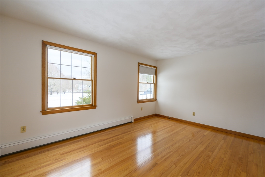 208 Rolling Ridge Road Amherst, MA 01002 - Photo 23 of 40 a view of an empty room with wooden floor and a window
