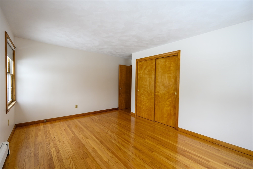 208 Rolling Ridge Road Amherst, MA 01002 - Photo 24 of 40 a view of an empty room with wooden floor and a window