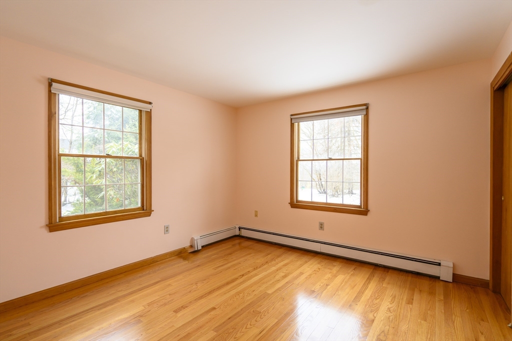 208 Rolling Ridge Road Amherst, MA 01002 - Photo 26 of 40 a view of an empty room with wooden floor and a window