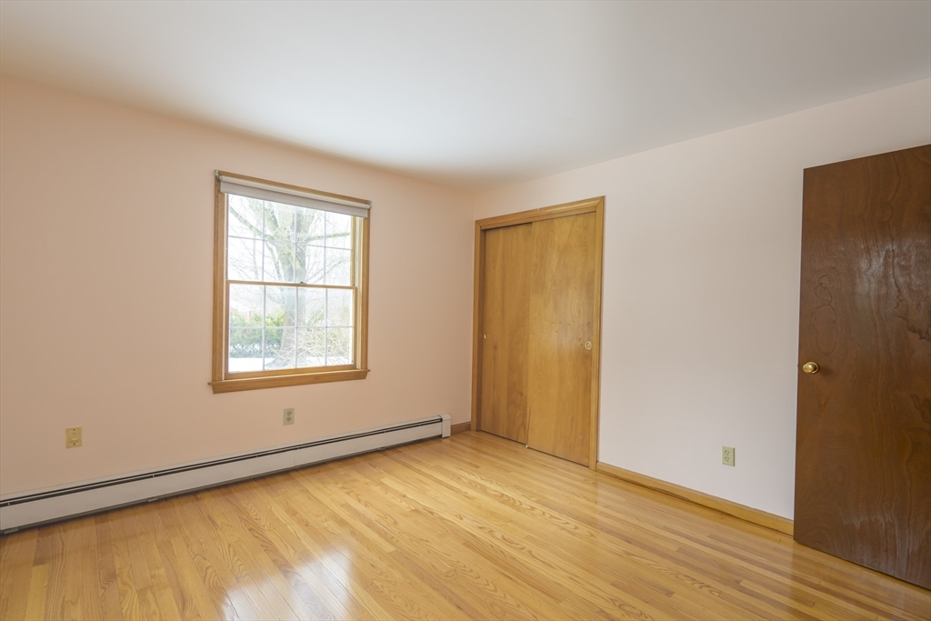 208 Rolling Ridge Road Amherst, MA 01002 - Photo 27 of 40 an empty room with wooden floor and windows