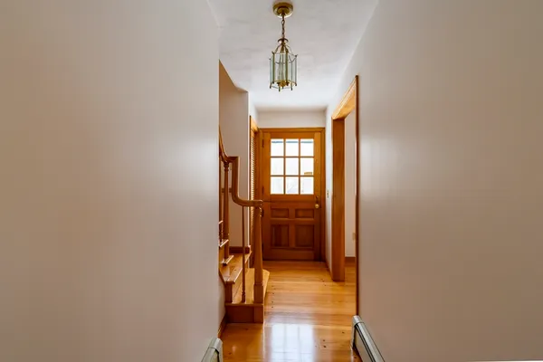 a hallway with a view of bedroom and wooden floor