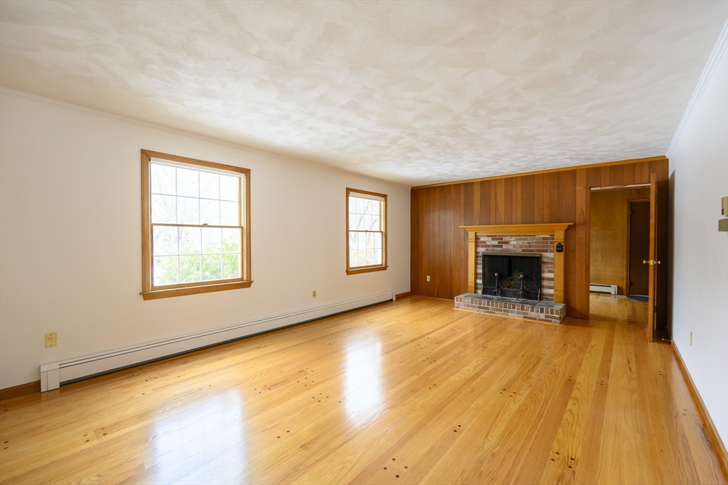 208 Rolling Ridge Road Amherst, MA 01002 - Photo 5 of 40 a view of empty room with wooden floor and fireplace
