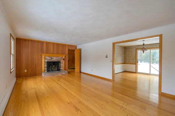 a view of an empty room with a fireplace and a window