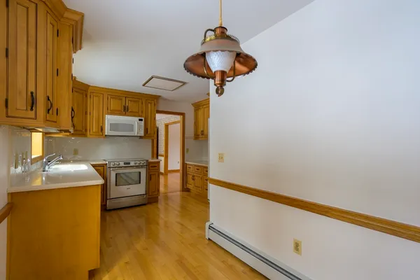 a kitchen with stainless steel appliances granite countertop a sink a stove top oven a counter space and cabinets