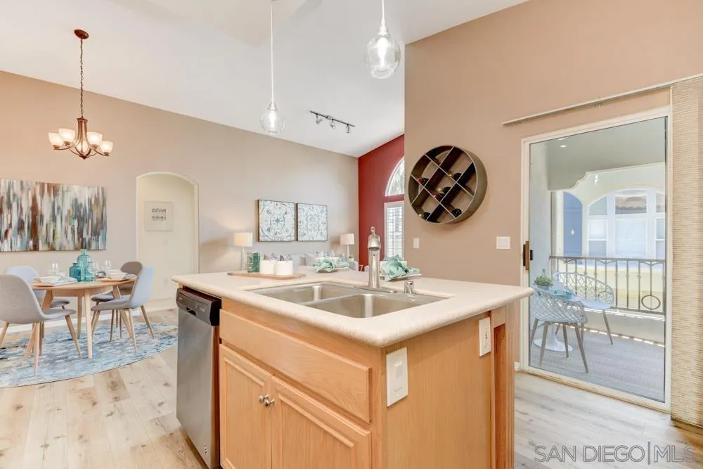 11650 Miro Circle San Diego, CA 92131 - Photo 12 of 28 a kitchen with a sink a stove and chairs with wooden floor