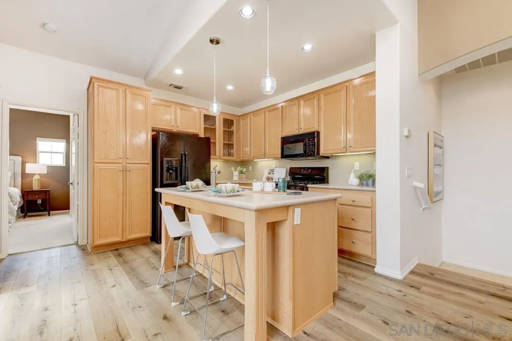 11650 Miro Circle San Diego, CA 92131 - Photo 13 of 28 a kitchen with a refrigerator a microwave oven cabinets and wooden floor