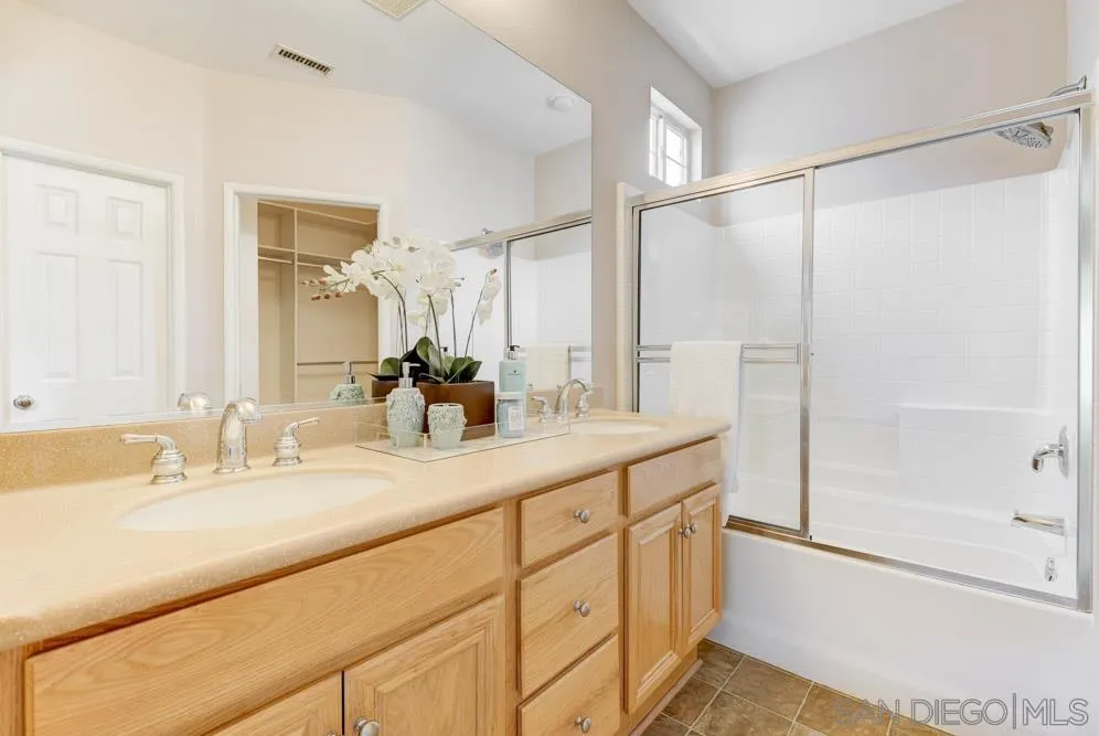 11650 Miro Circle San Diego, CA 92131 - Photo 17 of 28 a bathroom with a double vanity sink mirror and shower