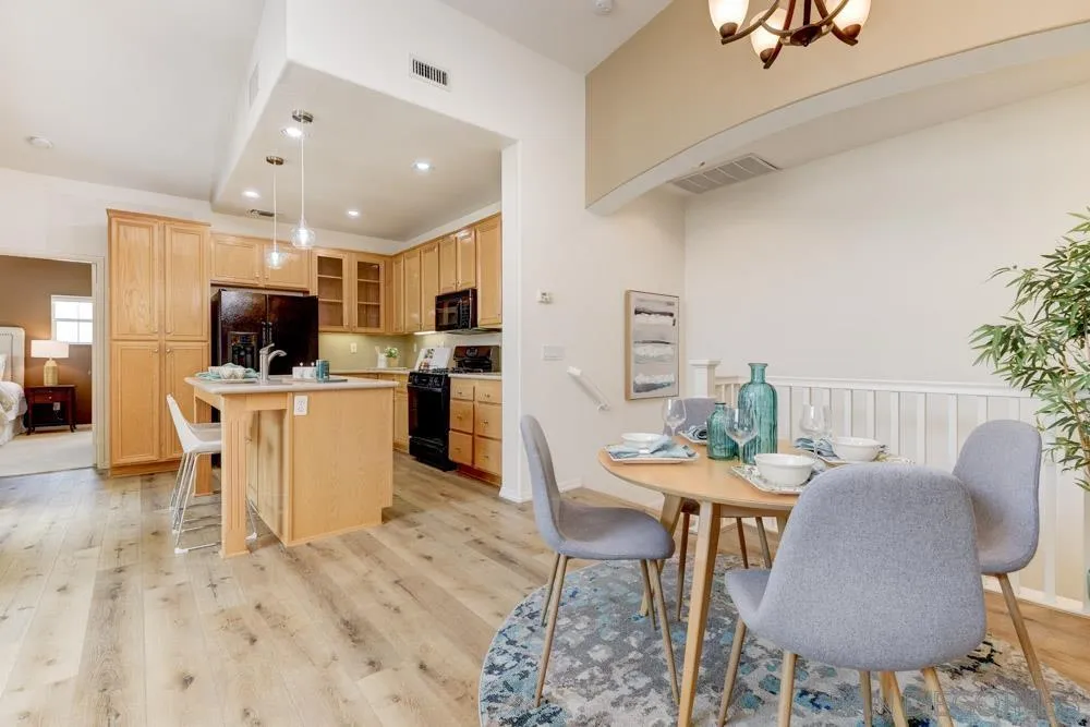 11650 Miro Circle San Diego, CA 92131 - Photo 9 of 28 a open kitchen with stainless steel appliances kitchen island granite countertop a sink and a stove top oven with wooden floor