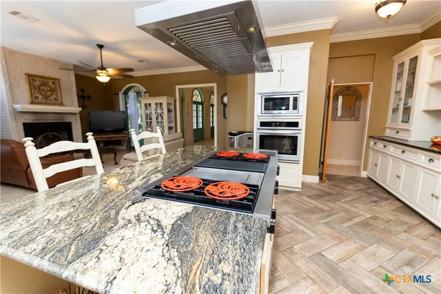 a kitchen with granite countertop a refrigerator and a stove