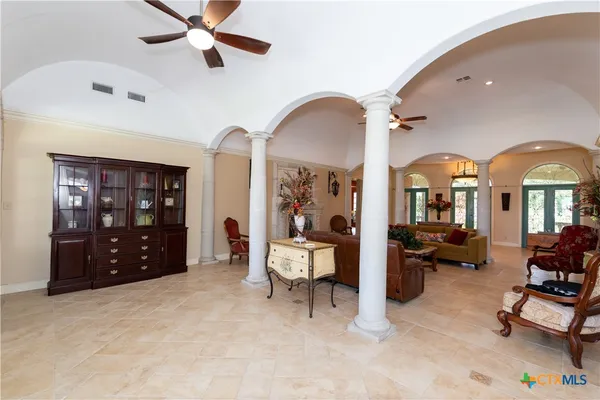 a living room with couches a fireplace and a dining table with garden view