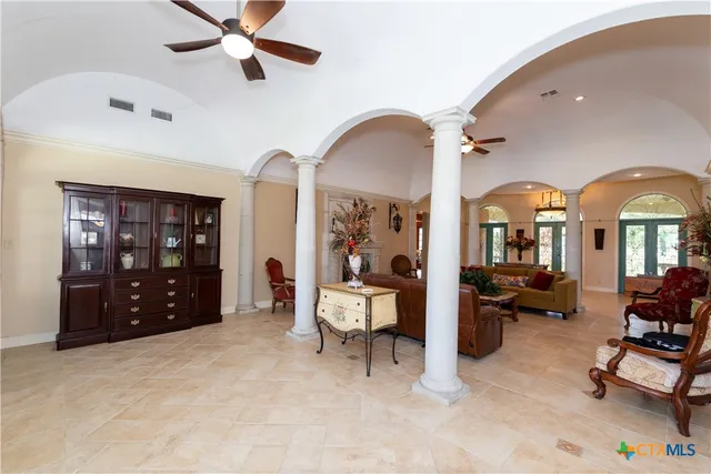 a living room with couches a fireplace and a dining table with garden view