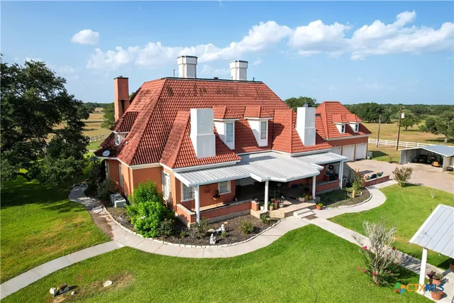 an aerial view of a house with garden space and street view