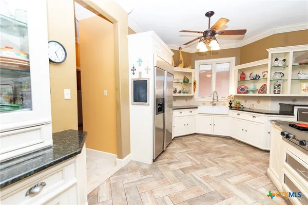 a kitchen with stainless steel appliances granite countertop white cabinets and window