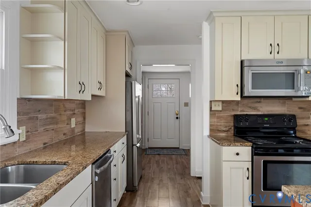 a kitchen with stainless steel appliances granite countertop a stove refrigerator and microwave