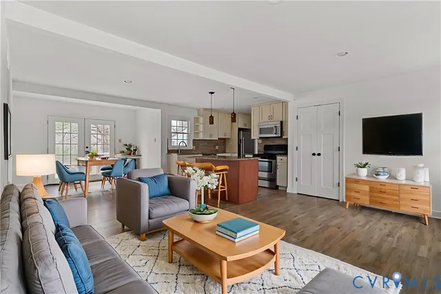 a kitchen with stainless steel appliances granite countertop a stove top oven a sink dishwasher and a refrigerator with wooden floor