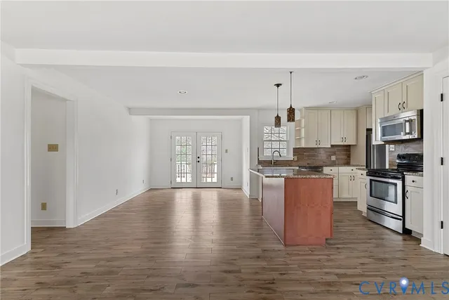 a view of open kitchen with wooden floor and electronic appliances