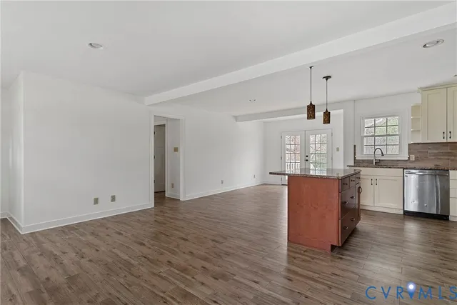 a kitchen with granite countertop a sink stove and cabinets