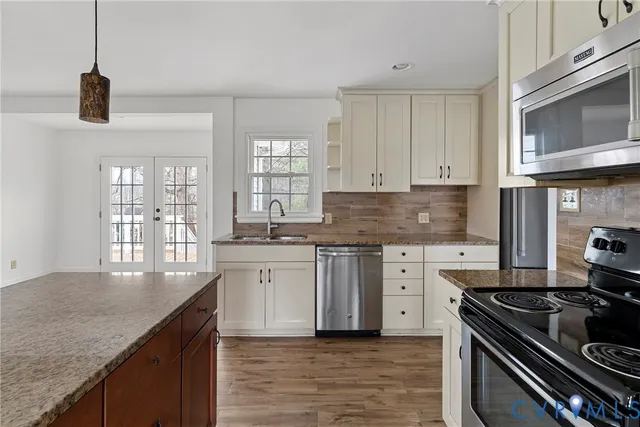 a kitchen with granite countertop white cabinets and a stove