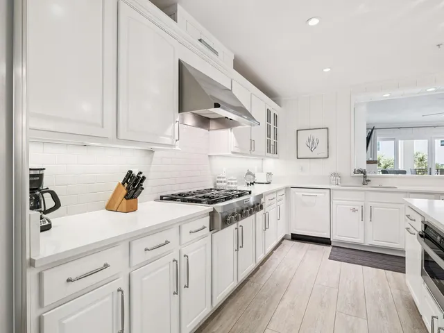 a kitchen with white cabinets sink and stove