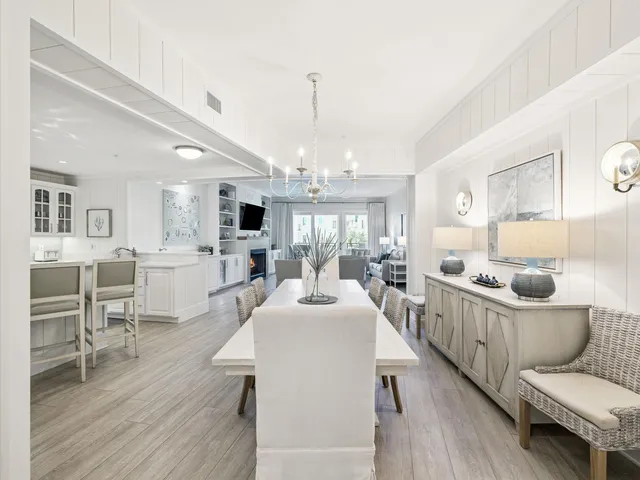 a room with stainless steel appliances a dining table wooden floor and a fireplace