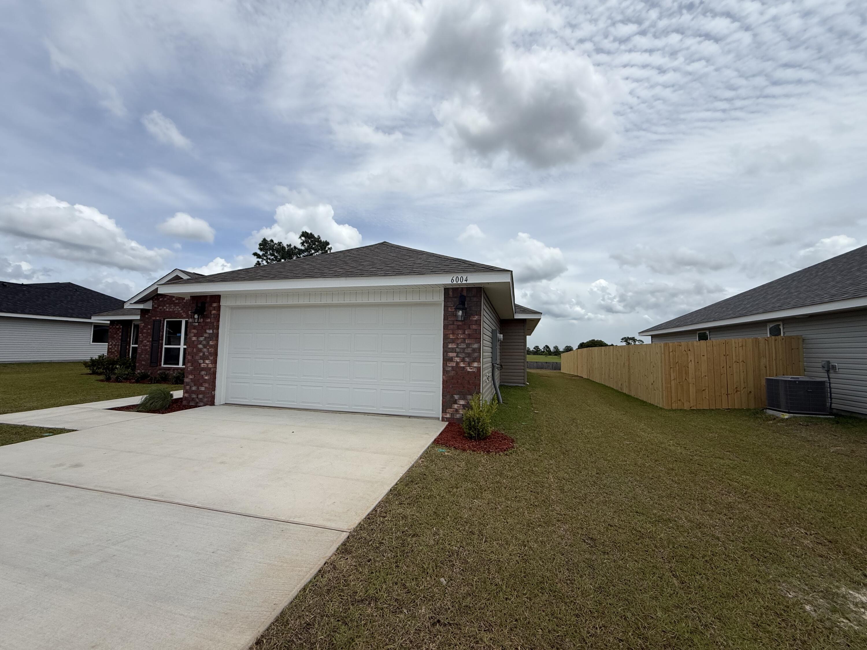 6004 Crocket Cove Crestview, FL 32539 - Photo 3 of 24 a view of a house with a yard and garage