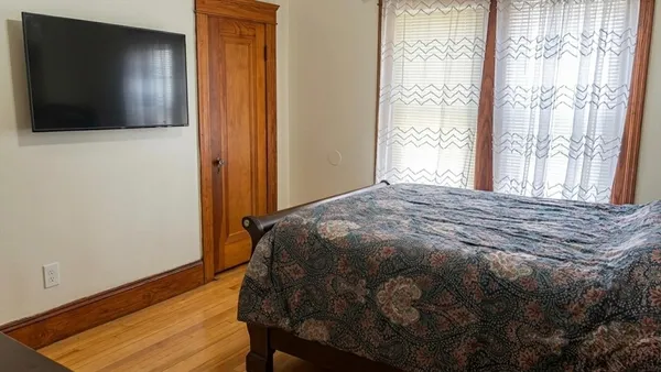 a bedroom with a bed and wooden floor